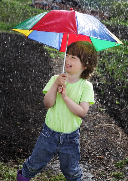 Gülen çocuk bir şemsiye altında — Stok fotoğraf