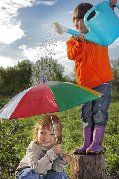 Два брати грають у дощ на відкритому повітрі — стокове фото
