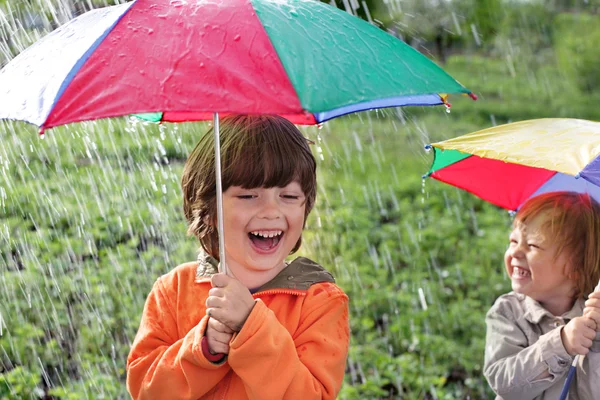 Açık havada şemsiye ile mutlu iki kardeş — Stok fotoğraf