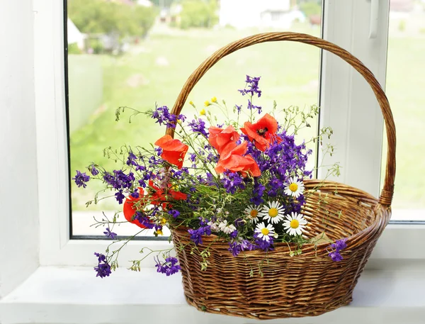 Boeket van wilde bloemen op een kunststof venster — Stockfoto