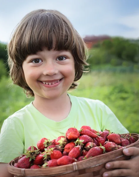 Fröhlicher Junge mit einem Korb voller Beeren — Stockfoto
