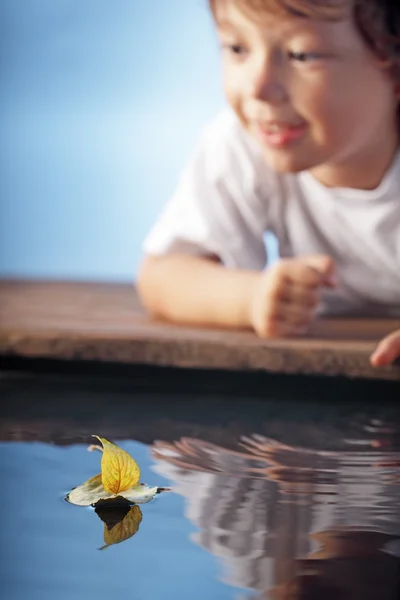 Lycklig pojke spela i blad skepp (fokus på fartyg) — Stockfoto