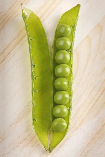 Groene erwt en afstandsensor op witte houten tafel — Stockfoto