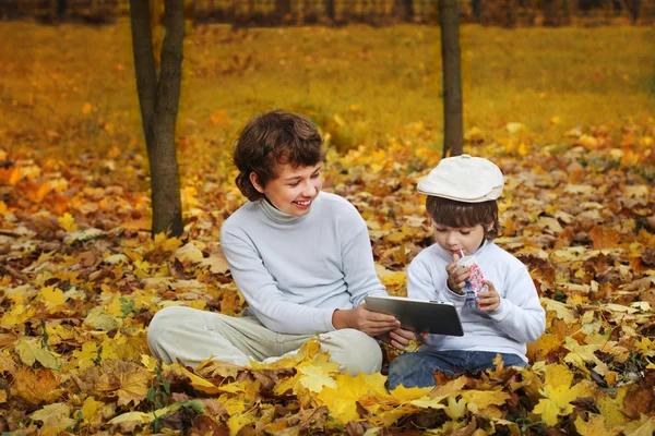 Niños felices en el parque usando una tableta PC — Foto de Stock