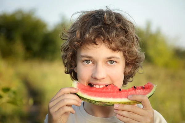 Gelukkig tiener watermeloen eten in de tuin — Stockfoto