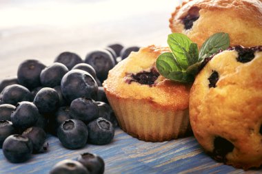 Ahşap bir masada yaban mersinli kek. Tahtada taze böğürtlen ve tatlı hamur işleri