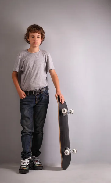 Ragazzo felice seduto su skateboard — Foto Stock