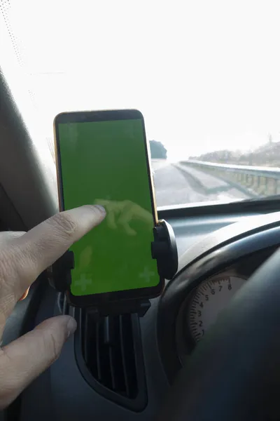 モックアップのための隔離された緑の画面と現代のスマートフォン 運転手は車の道路で電話を使う — ストック写真