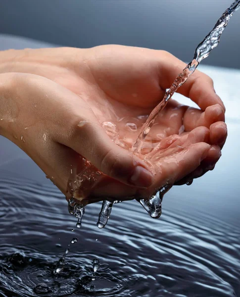 Νερό Χύνοντας Στο Χέρι Γυναίκα Μπλε Φόντο — Φωτογραφία Αρχείου