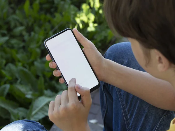 Підліток Тримає Чорний Смартфон Порожнім Екраном Сучасним Безкаркасним Дизайном Фоні Ліцензійні Стокові Зображення