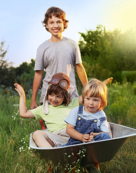 Tři Přátelé Hraje Rovině Pomocí Zahradní Vozíky Zaměření Pouze Dítě Stock Obrázky