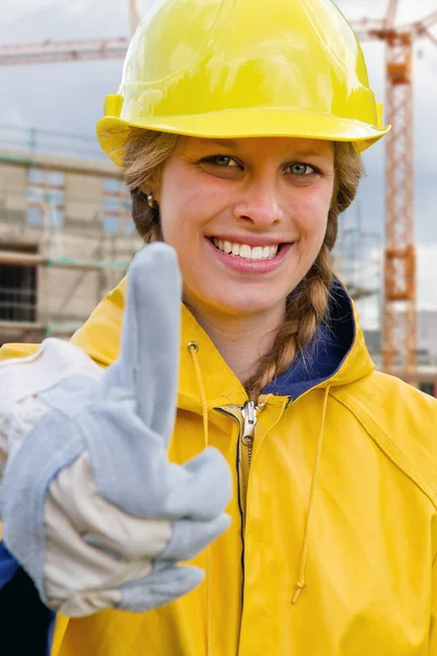 在建筑工地上长着大拇指的年轻女人 — 图库照片