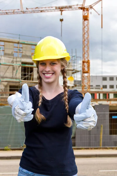 在建筑工地上长着大拇指的年轻女人 — 图库照片