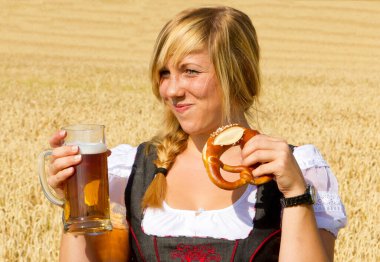 Elinde bira bardağı ve kraker olan genç bir kadın.