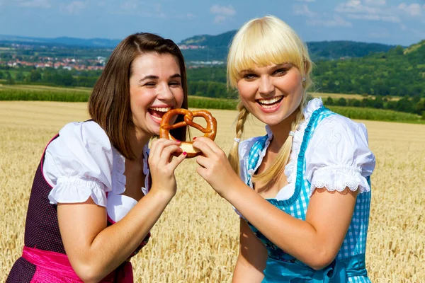 Two Girls Dirndls Eating Pretzel Wheat Field — 스톡 사진