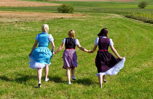 Three Girls Colorful Dirndl Walking Meadow —  Fotos de Stock