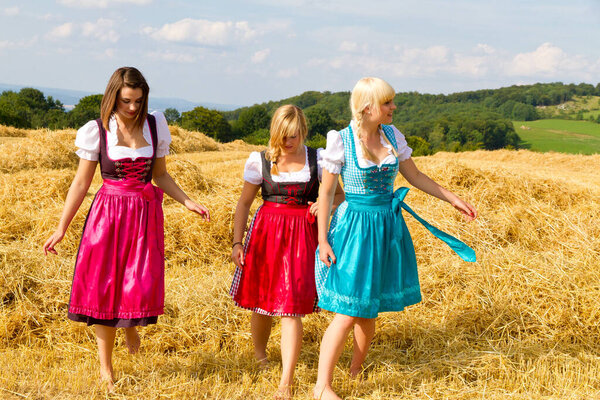 Three young women in colorful dirndls