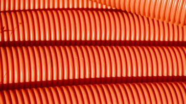 Red corrugated plastic tubes. Industrial background. Products from plastic. Drainage and sewerage. Urban network.