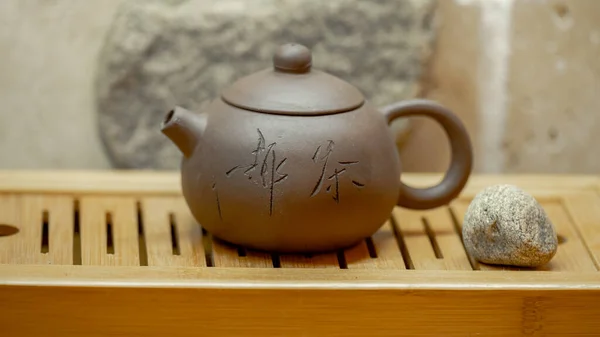 Traditional clay teapot with green tea. Clay teapot on wooden background