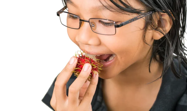 Kleines Mädchen isst Rambutan-Früchte — Stockfoto