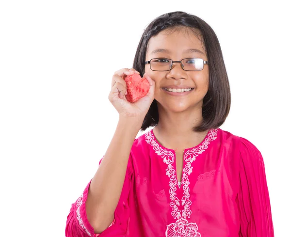 Kleines Mädchen mit einem roten Herz aus Wassermelone — Stockfoto