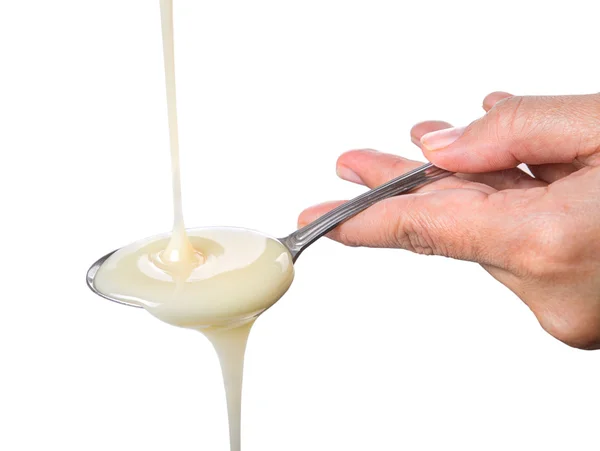 Cream pouring onto a spoon i — Stock Photo, Image