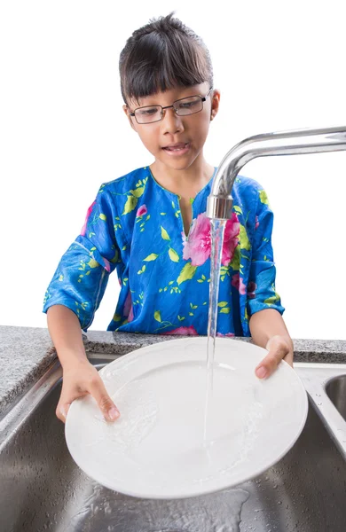 Молодая девушка моет посуду — стоковое фото