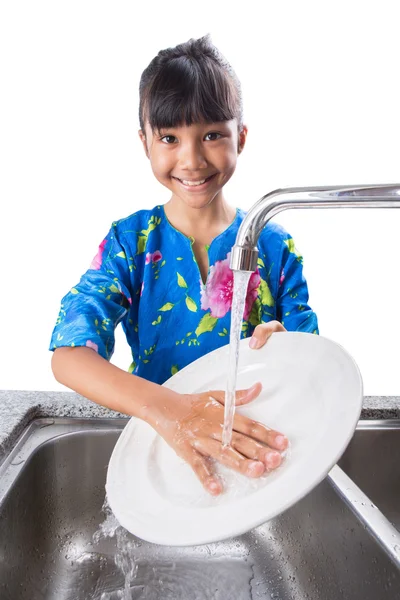 Молодая девушка моет посуду — стоковое фото