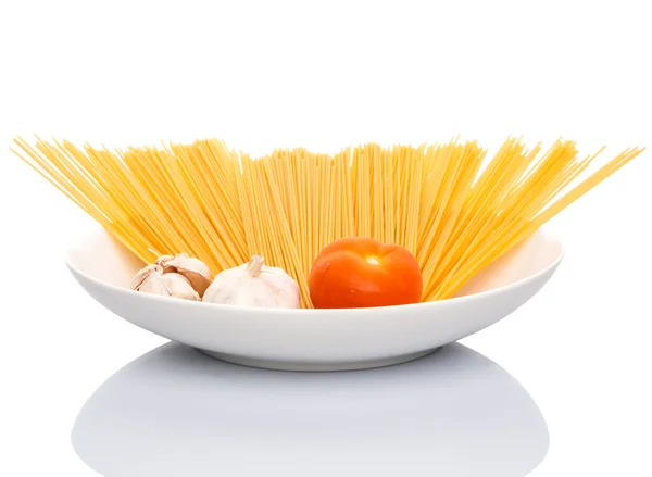 Чеснок, помидор и сухие спагетти — стоковое фото