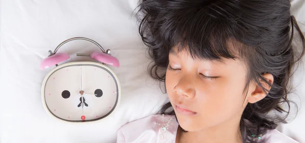 Menina jovem dormir com relógio de alarme — Fotografia de Stock