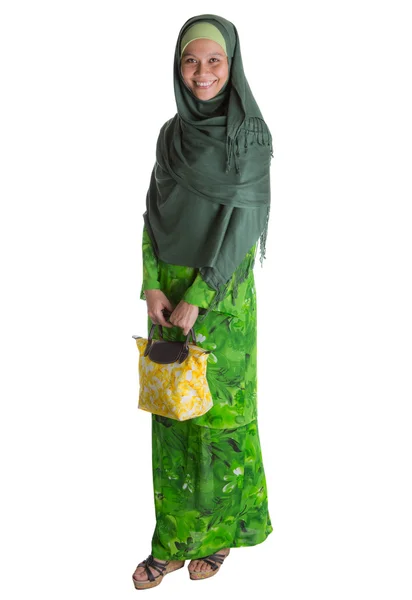 Femme musulmane en robe verte avec sac à main jaune — Photo