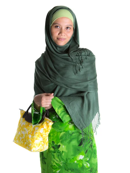 Muslimsk kvinna i grön klänning med gula handväska — Stockfoto