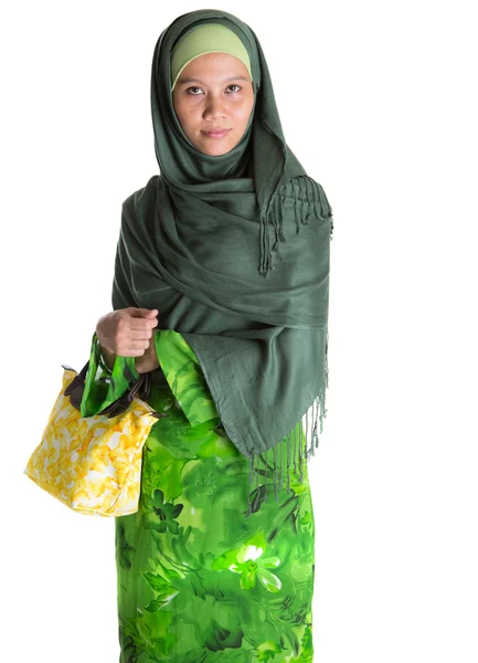 Мусульманка в зеленом платье с желтой сумочкой — стоковое фото