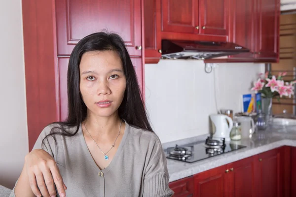 在她的厨房里的亚洲女性 — 图库照片