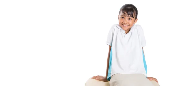 Scuola ragazza seduta su divano — Foto Stock