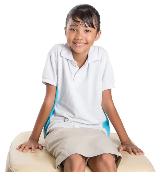 Шкільна дівчина сидить на дивані — стокове фото