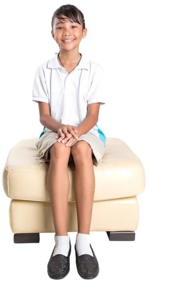Школьная девочка сидит на диване — стоковое фото