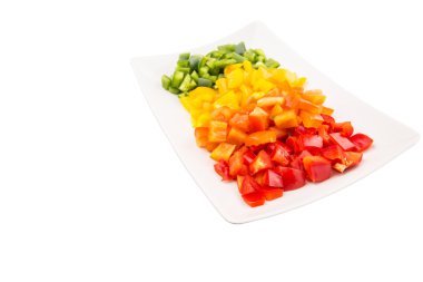 bir plaka beyaz arka plan üzerinde renkli doğranmış capsicums