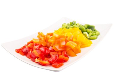 bir plaka beyaz arka plan üzerinde renkli doğranmış capsicums