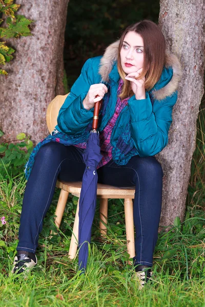 Jeune femme assise dans la forêt — Photo