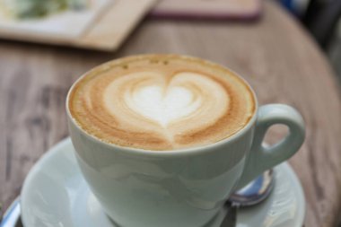 Süt köpüğünden kalbi olan bir bardak kapuçino. 