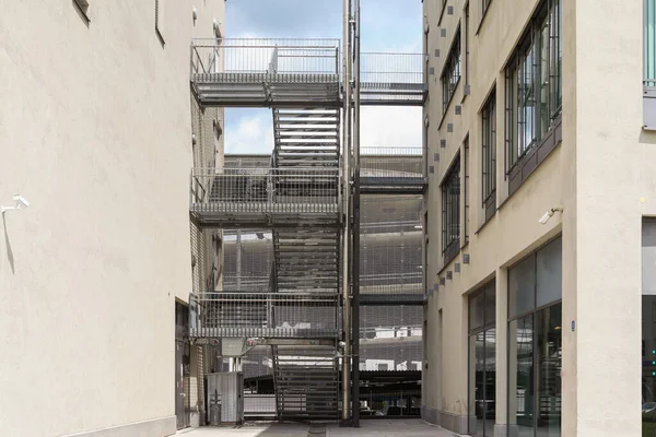 Outdoor stairs between two houses at a parking garage with stores - landscape format