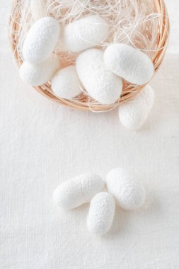 Beyaz ipek böceği kozaları, kumaş sepetinin içindeki ipek kumaş kaynağı, kopyalanmış boşluk.