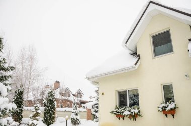 Kışın kırsal bir bölgede, kar altında özel bir ev ve bahçesi.