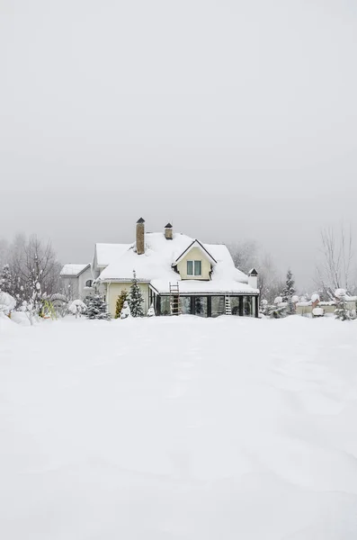 冬の田舎の雪の下の民家と庭 ストック画像