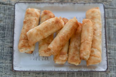 Yakın plan kızarmış börekler masanın üzerinde fillo hamuru tarafından yapıldı. Geleneksel Türk ve Balkan yemekleri