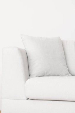 Oturma odasındaki yeni ve rahat kanepede gri bir yastığın yakın çekimi.