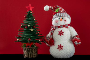 Noel kartı, Noel arkaplanı, çam ağacı ve kırmızı yüzeyde kopyalanmış kardan adam süslemeleri. Noel ya da Noel süsleri kırmızıda. yeni yıl kartı