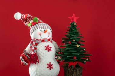 Noel kartı, Noel arkaplanı, çam ağacı ve kırmızı yüzeyde kopyalanmış kardan adam süslemeleri. Noel ya da Noel süsleri kırmızıda. yeni yıl kartı