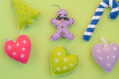 Noel, el yapımı Noel süsleri ya da yeşil yüzeyde izole edilmiş dekorasyonlar. Neon yeşil arkaplanda yeni yıl veya noel selamlaması